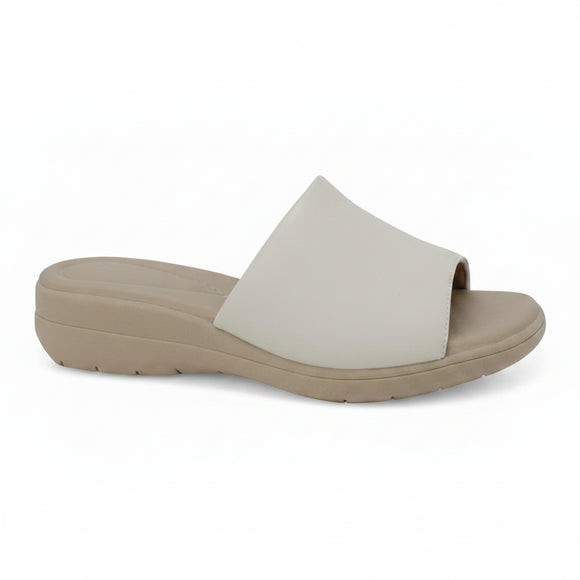 A single slide sandal with a wide, flat strap in a light off-white color and a thick, low-profile wedge sole in a warm taupe-beige, shown from a side profile view against a plain white background.