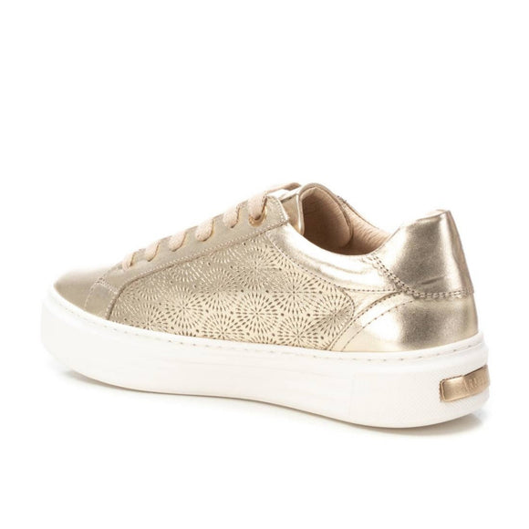 Gold carmela sneaker with white sole on a white background