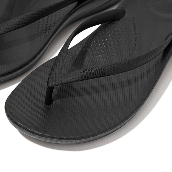 FitFlop iQushion All Black flip-flops, close-up of textured straps and footbeds