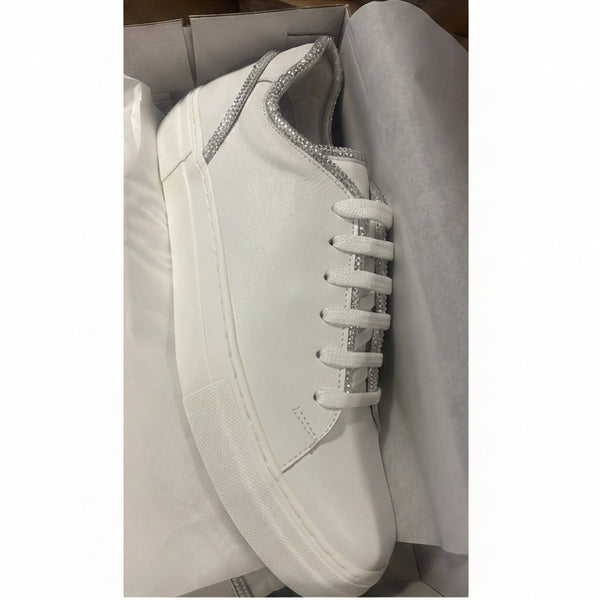 A white leather sneaker with silver glitter trim along the collar and white laces, resting inside its white shoebox with white tissue paper.