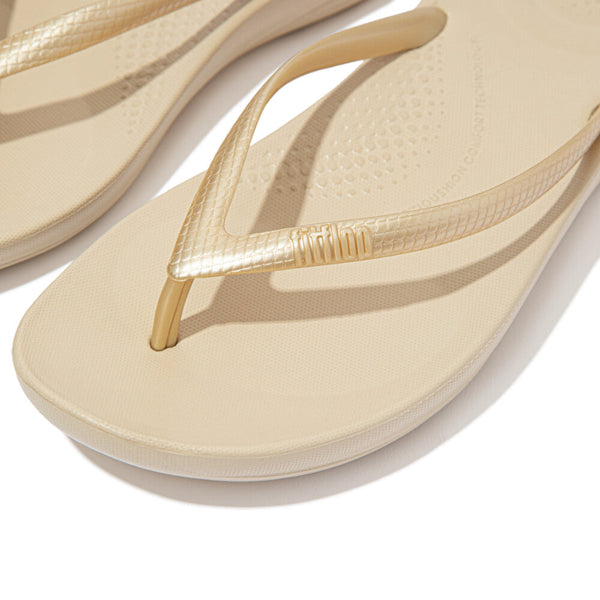 FitFlop iQushion Gold flip-flops, close-up showing metallic strap texture and footbed